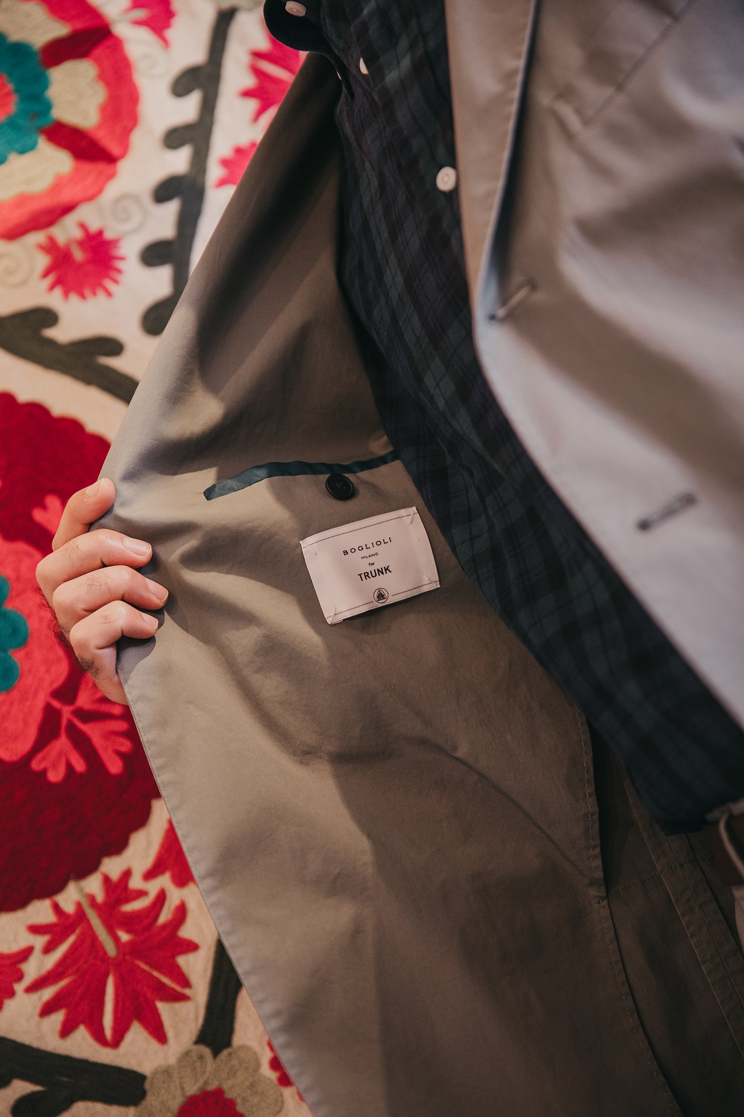 Close-up of a jacket with a Boglioli tag on a colorful patterned rug