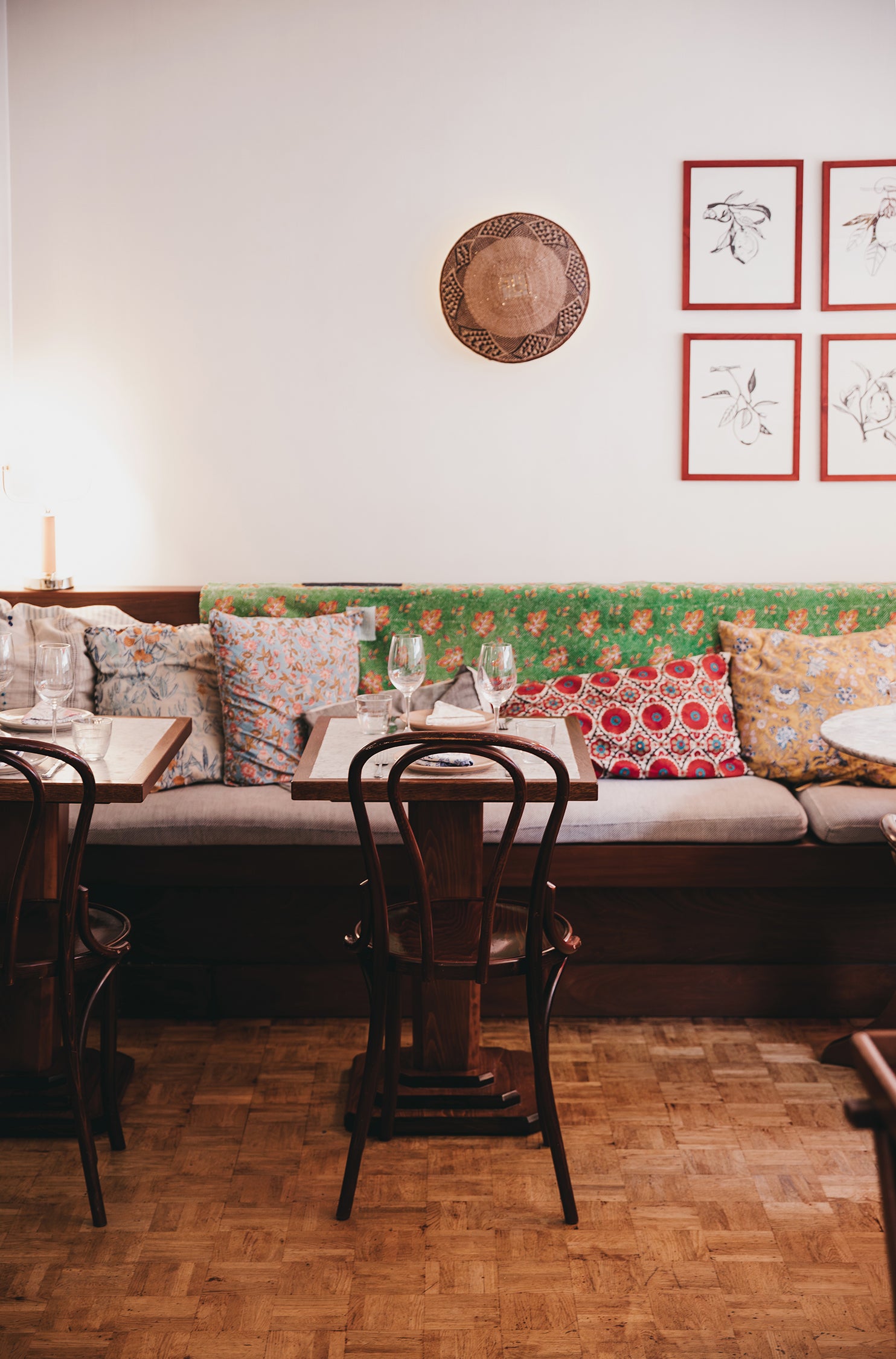 Jikoni restaurant interior with a booth, chairs, and decorative pillows.