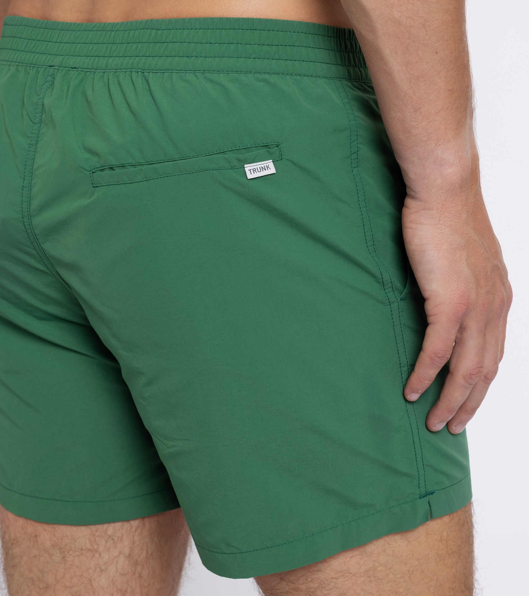 Trunk Foley swim shorts in green, styled shot.