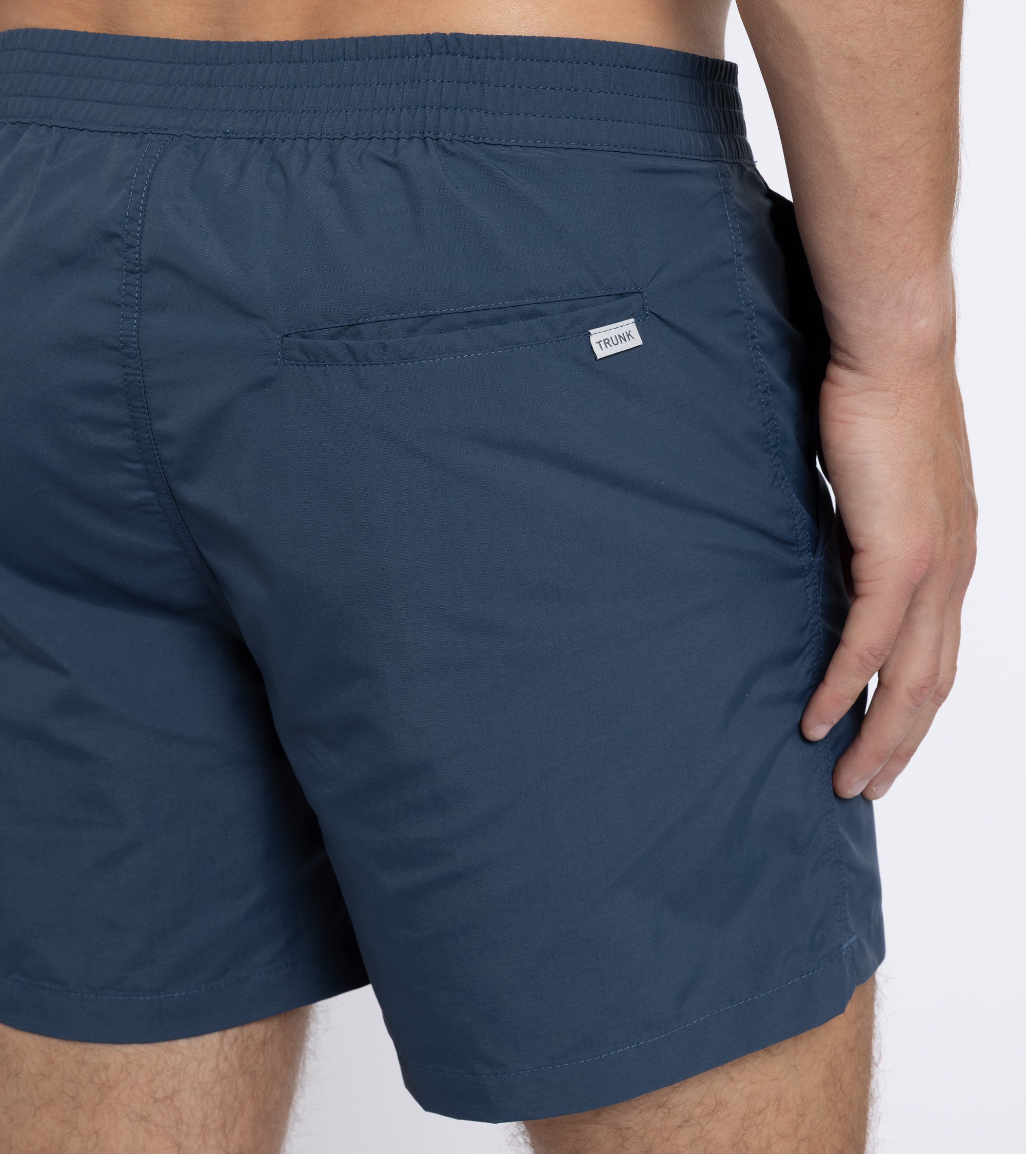 Trunk Foley swim shorts in navy, styled shot.