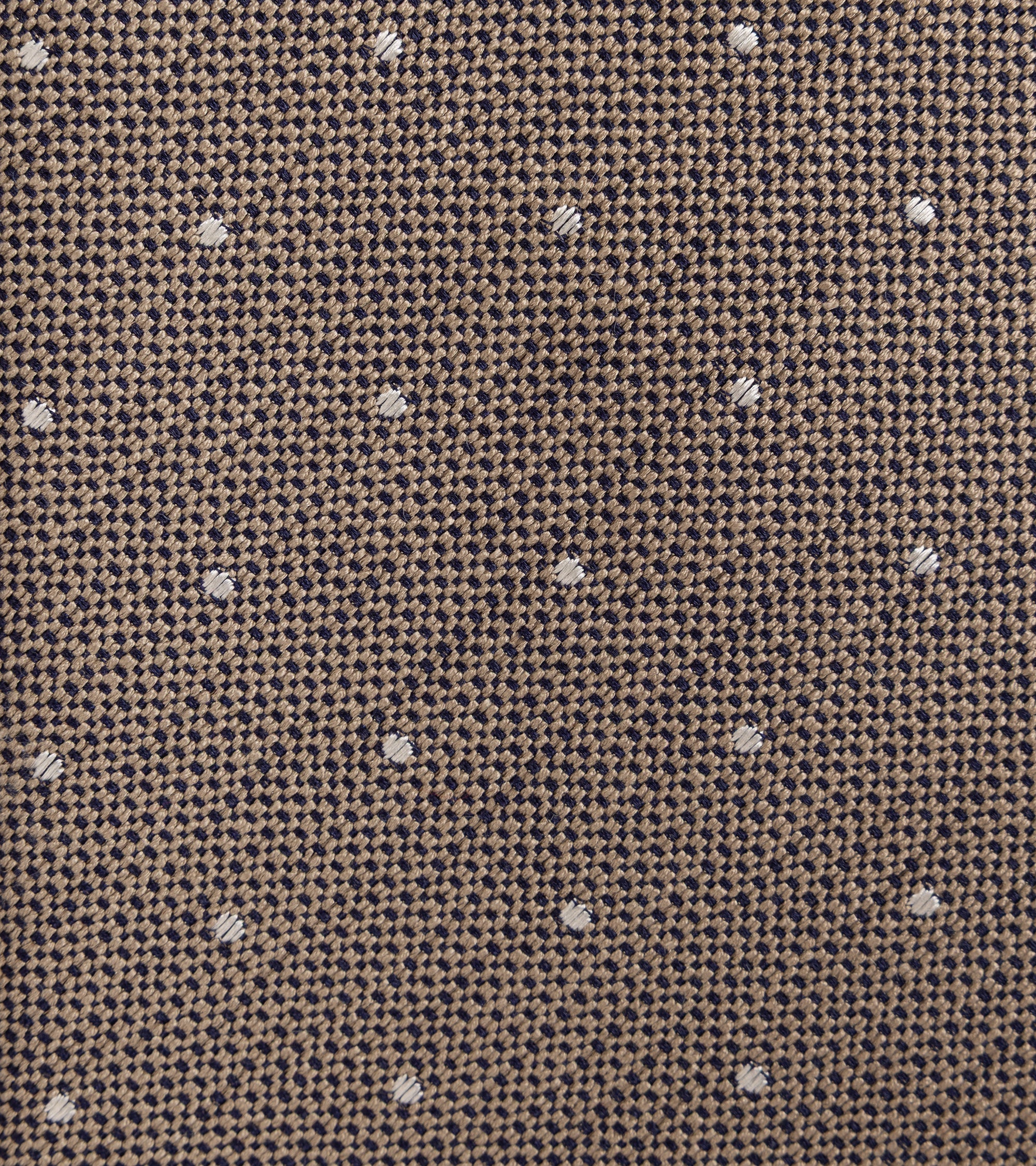 Close-up of a woven fabric texture in a brown and beige houndstooth pattern with small scattered white polka dots.